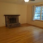 Main room has plenty of light from windows on right.  Fireplace (decorative-only; a great place to hang stockings!) is on the left.