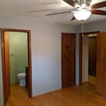 Master bedroom has a ceiling fan; private bath on the left, walk-in closet through the center door and the hallway is through the door on the right.